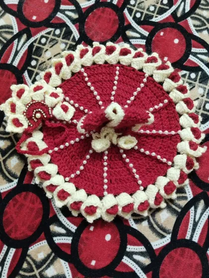 An elegant winter poshak in deep red, with an off-white border and intricate pearl work. This dress comes with a matching pagdi, also decorated with pearls.
