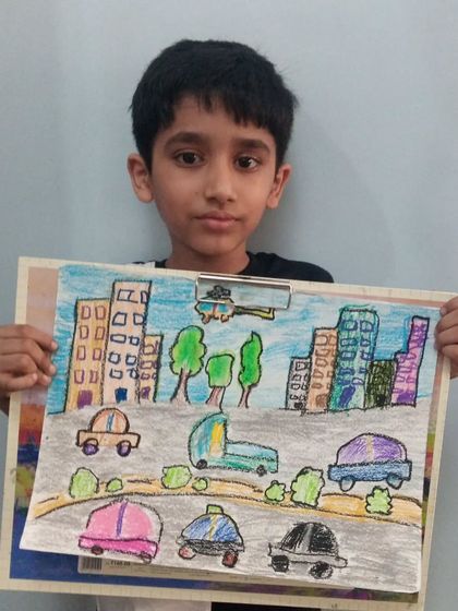 Ankur, a 2nd standard student, drew this busy city landscape. His oil pastel drawing includes buildings, trees, and cars, showing his understanding of perspective.