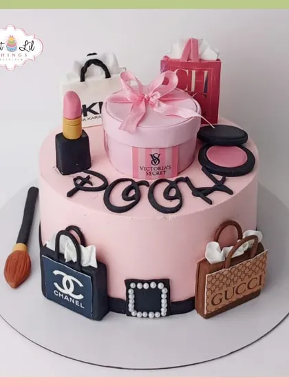 A shopaholic's dream cake for Pooja. This pink cake is adorned with edible shopping bags and boxes from Chanel, Gucci, and Victoria's Secret, along with makeup items.
