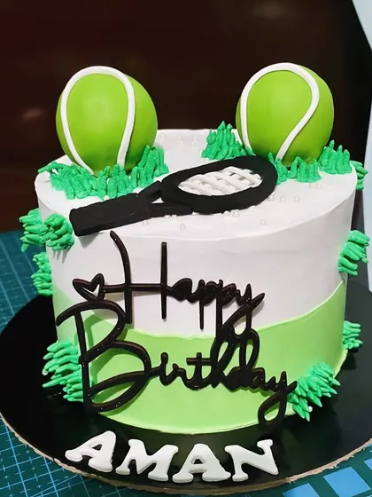 Game, set, match! This tennis-themed cake is perfect for a tennis lover's birthday. It's decorated with fondant tennis balls and a racquet on a court-inspired green and white base.