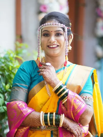 A smiling portrait of a bride ready for her Vidhi. The makeup is fresh and clean, with a focus on enhancing her natural beauty.