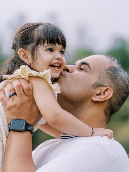 A father's kiss and a daughter's giggle. This is the kind of spontaneous affection I aim to capture, a timeless expression of love.