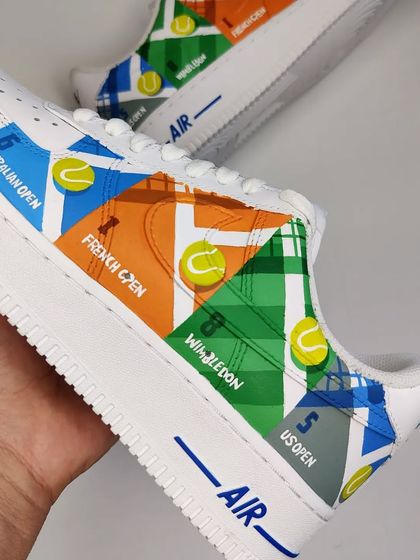 A tribute to the G.O.A.T, Roger Federer, on a pair of crisp white Nike Air Forces. This side showcases the Grand Slam titles he has won throughout his illustrious career.