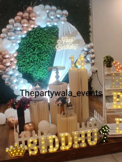 A stylish ring decoration with a green foliage backdrop. The rose gold, silver, and white balloons create a beautiful contrast with the green wall.