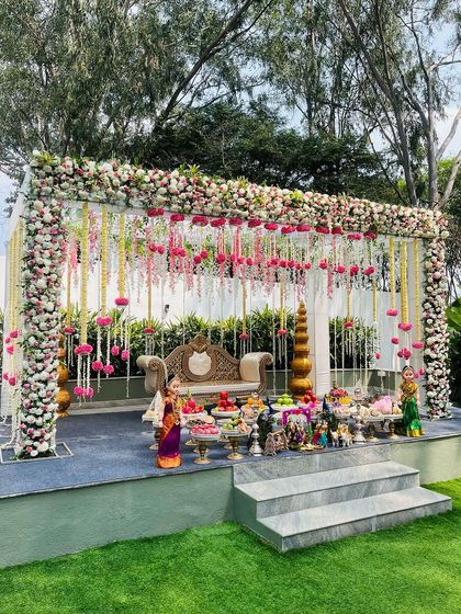 For outdoor Seemantham ceremonies, I design open-air mandapams like this one. The structure is draped in dense floral arrangements and hanging garlands, creating a breathtaking stage amidst nature.
