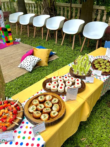 A beautiful spread for a kids' garden party, featuring fruit skewers, mini sandwiches, and veggie buns. I focus on fresh, colorful, and easy-to-eat options.
