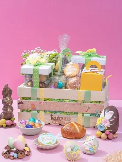 A grand Easter hamper in a wooden crate, filled with an abundance of my festive treats including a piñata egg, chocolate bunny, hot cross buns, and decorated cookies. This is the ultimate gift for a family to share.