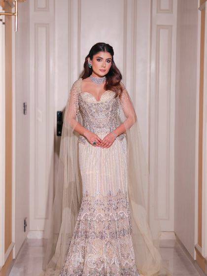 A full-length view of this incredible couture look. The bronzed makeup and soft waves in her hair complete this vision of modern, high-fashion elegance for a reception or cocktail party.
