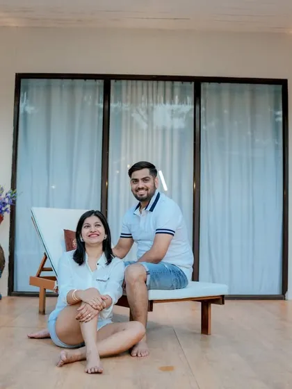 A relaxed and intimate moment at a modern resort-style location. This shot captures the couple enjoying a quiet celebration with champagne, showcasing a casual yet sophisticated pre-wedding vibe.