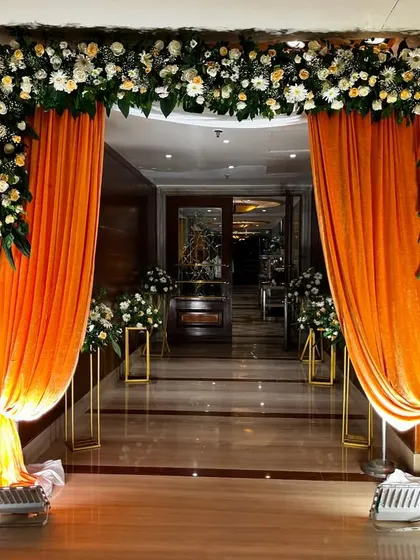A closer look at the entrance decor, showing how the lighting highlights the rich color of the drapes.