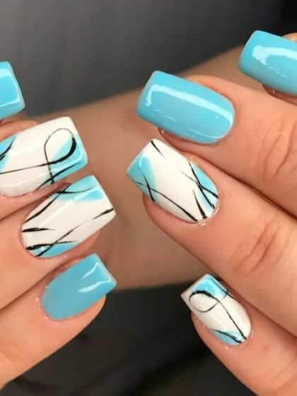 A fun design with light blue nails and accent nails featuring abstract black squiggles over a white base.