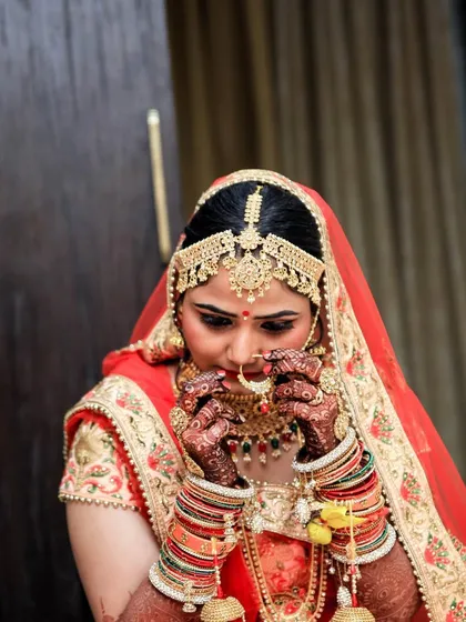 A candid getting-ready shot of a bride adjusting her nose ring. These small, focused moments are a beautiful part of the wedding day story.