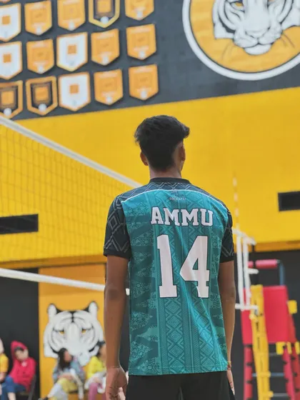 A player wearing his jersey with pride. The number on the front and the name on the back represent the whole team's effort.