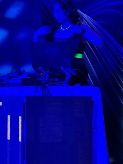 A candid shot of me DJing under cool blue stage lights at a private party. The neon necklace was a fun touch for this neon-themed section of the night.