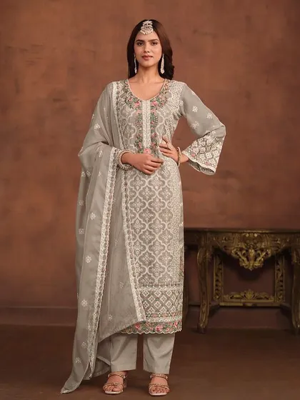 A graceful grey salwar kameez with delicate floral and geometric thread embroidery. The organza fabric and detailed hem on the pants and dupatta add a touch of luxury.