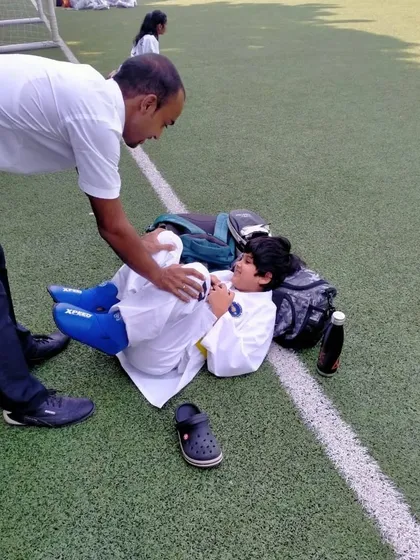 A coach tends to a student between matches, showing the care and attention given to each athlete.