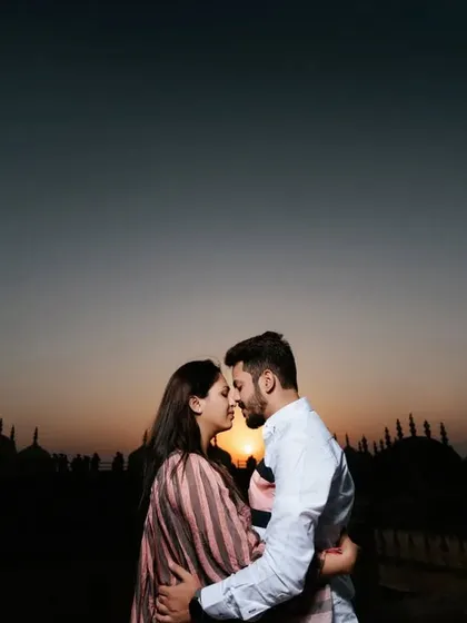 A classic silhouette shot of a couple against the setting sun, with the domes of a Jaipur fort creating a beautiful skyline. This is a must-have romantic shot for any pre-wedding album.