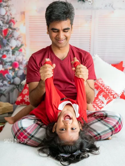 The joy of Christmas is often found in playful moments, like this dad having fun with his daughter in their matching holiday pajamas.