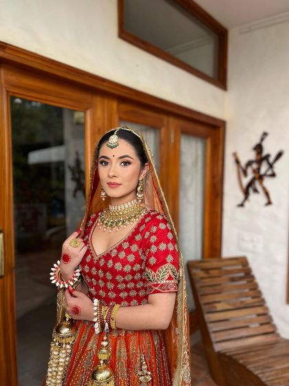 I am currently open for bridal bookings. This look, with its classic red and orange lehenga, is a perfect example of the timeless elegance I love to create.