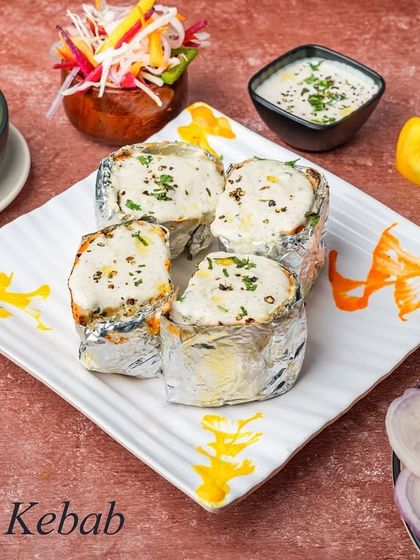 This is our Moroccan Kebab, a house specialty. Minced chicken is stuffed with cheese, wrapped in foil, and cooked until tender, then topped with a creamy sauce.