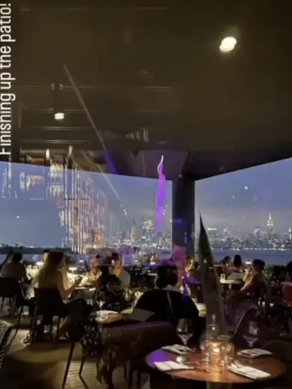 The patio at LokalJC in Jersey City, with the Manhattan skyline reflecting in the glass. We designed this space to offer a premium waterfront dining experience, day or night.