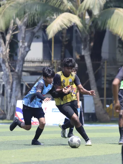 Two players in a tight contest for the ball. Our player shows strength and determination to maintain possession under pressure.