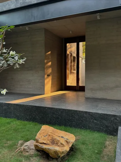A sneak peek of the nearly completed 6AM House. The structure, with its raw concrete walls and large openings, emerges from its context, creating a unique relationship with the surrounding landscape.