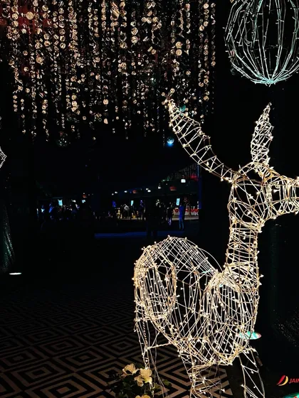 A touch of whimsy for a starry night theme. This illuminated deer sculpture stands amidst a ceiling of hanging crystals, adding a magical and unexpected element to the sangeet decor.
