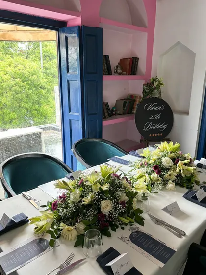 A full view of the birthday lunch setup. My indoor area, with its vibrant blue doors and unique architectural details, provides a stunning backdrop for daytime events.