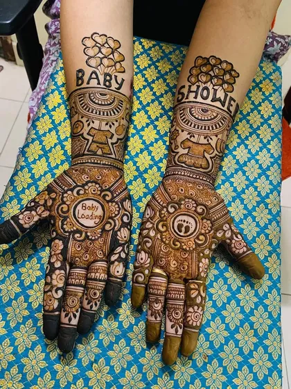Celebrating the journey to motherhood with a custom baby shower mehndi. This design includes cute elements like 'Baby Loading', tiny footprints, and 'Baby Shower' spelled out with heart balloons.