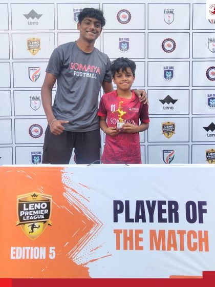 Madhav Verma of the Somaiya FC U-8 team receives the Player of the Match trophy from his coach at the Leno Premier League.