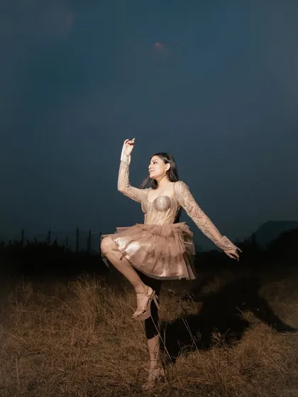 A high-fashion outdoor shoot for Zoya Thakur Designs. The dramatic pose and the twilight sky create an artistic, ethereal look for this couture gown.