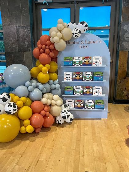 A themed party favor display for the Toy Story party, designed to look like a toy shelf and decorated with a balloon garland.