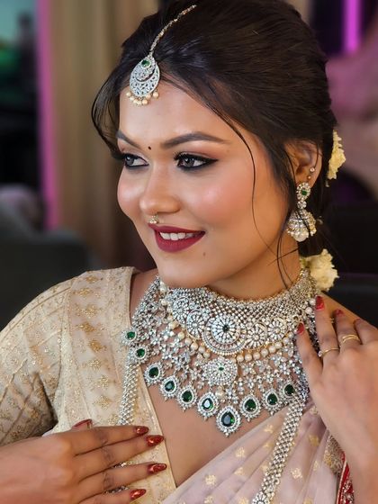 Another angle of this beautiful look, highlighting the intricate details of the diamond and emerald necklace and the soft, elegant updo.