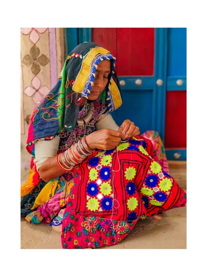 A Meghwal woman in Kutch is deeply focused on her intricate embroidery work. This craft is a visual language for her community, with every stitch telling a story.