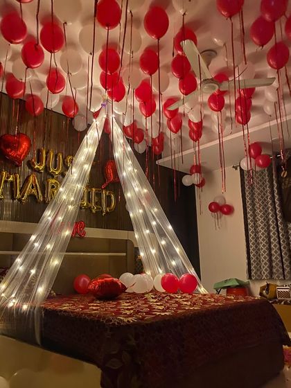 The combination of red and white balloons with a golden "Just Married" sign is a timeless choice for wedding night room decor.