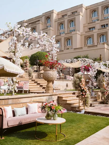 A beautiful Mehendi lunch setup at Oberoi Amarvilas. The decor is a vision in pink, with elegant sofas, floral arrangements, and a stunning heritage backdrop.