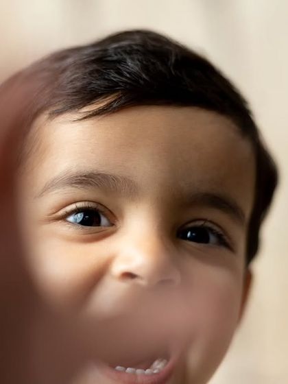 A playful and interactive shot where the little boy reaches for the camera, resulting in a fun and engaging portrait.