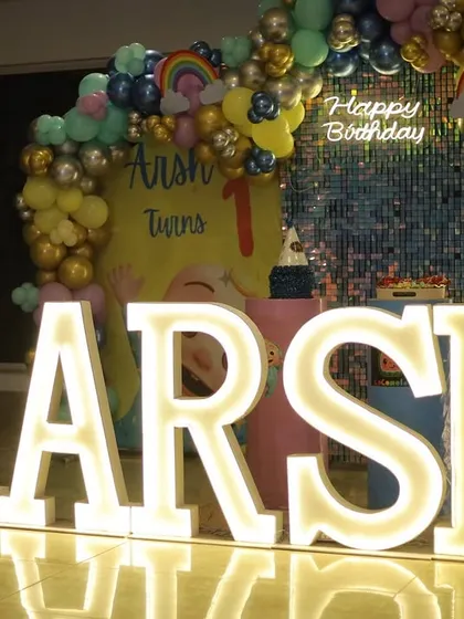 Arsh's Cocomelon party featured a silver sequin wall and a balloon arch with rainbow and cloud details, creating a bright and cheerful atmosphere.