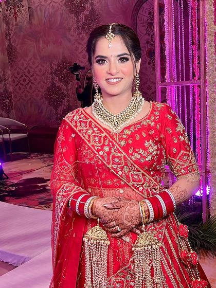 Aanchal looking absolutely stunning on her wedding day. The soft glam makeup with a touch of pink glitter on the eyes perfectly complemented her red and gold lehenga.