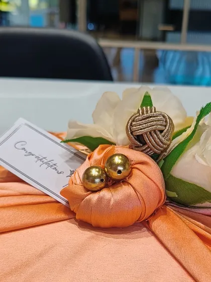 A close-up of the elegant Furoshiki-style fabric wrapping in a lovely peach color, adorned with a 'Congratulations' card. This is our signature satin wrap.