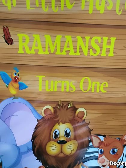 A close-up of the custom-printed backdrop, showing the personalized text and the adorable cartoon animals that bring the jungle theme to life.