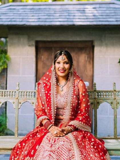 A beautiful portrait of a bride we styled in a classic red lehenga. Her minimal jewelry and radiant smile create a look of timeless elegance for her wedding day.