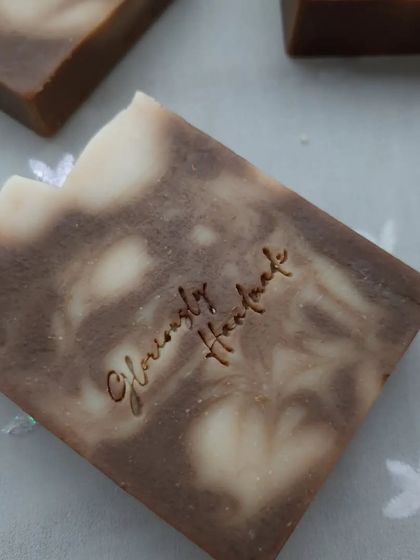 A single bar of Neem Cucumber soap, showing the intricate swirl pattern up close. Each bar is stamped by hand, a final touch to my artisanal process.