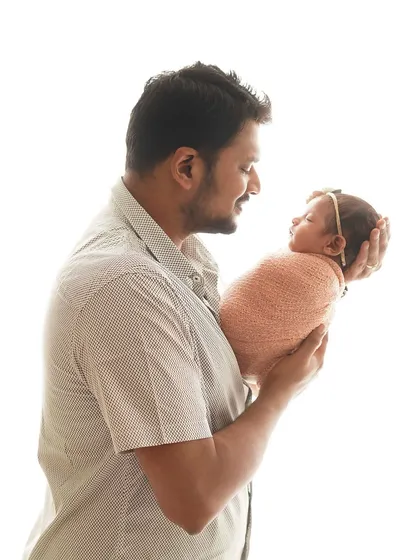 A father's silhouette as he holds his newborn up to the light. This artistic shot is a powerful representation of new fatherhood.