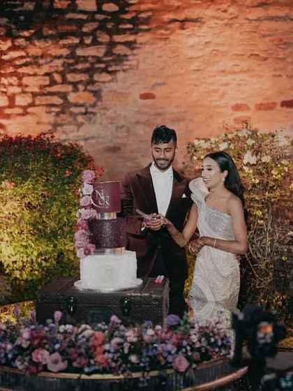 The cake cutting ceremony, a sweet moment with a beautiful multi-tiered cake adorned with fresh flowers.