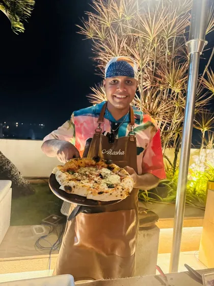 Serving up a freshly baked pizza at a New Year's Eve party. My outdoor catering setup is perfect for evening events, adding a warm, inviting glow.
