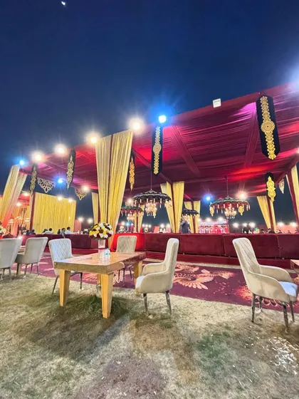 A view of the lounge seating at night, with the deep red and gold colors of the tent creating a royal atmosphere.
