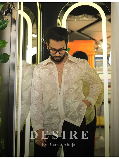 A pensive moment in the sheer floral embroidered shirt. The delicate fabric and intricate stitching create a look of modern, romantic masculinity.
