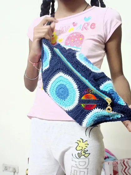 Here is a custom crochet fanny pack I made with a trendy Evil Eye design, modeled by my daughter. These pouches are great for kids to carry their small treasures and can be customized with different colors and themes.